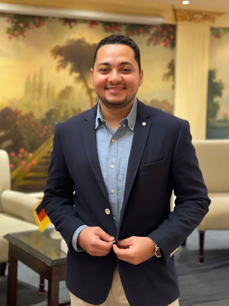 Ahmed Essam, the learner behind Piece of Dutch, smiling in a navy blazer